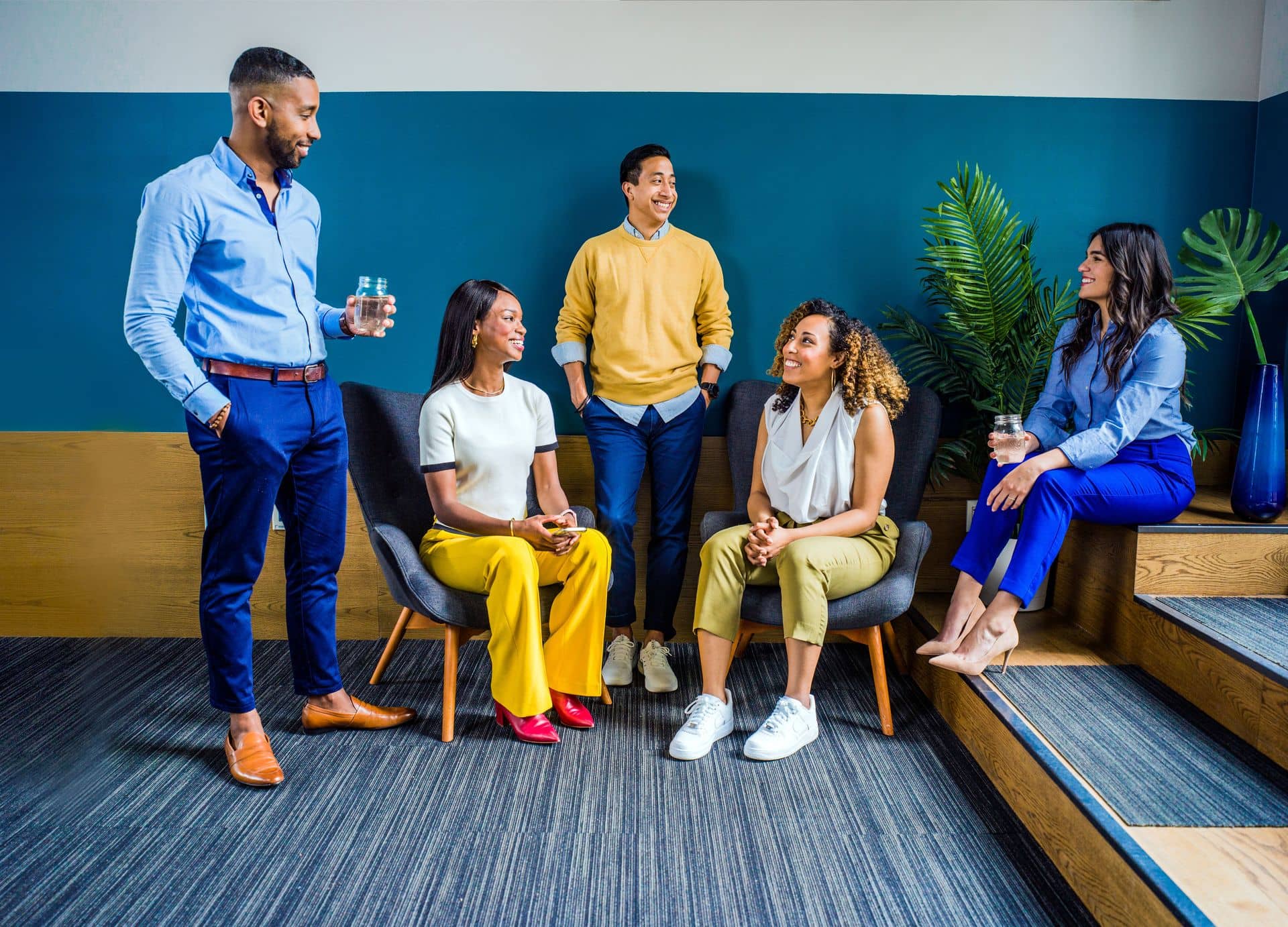 Five colleagues talking together in an office lounge