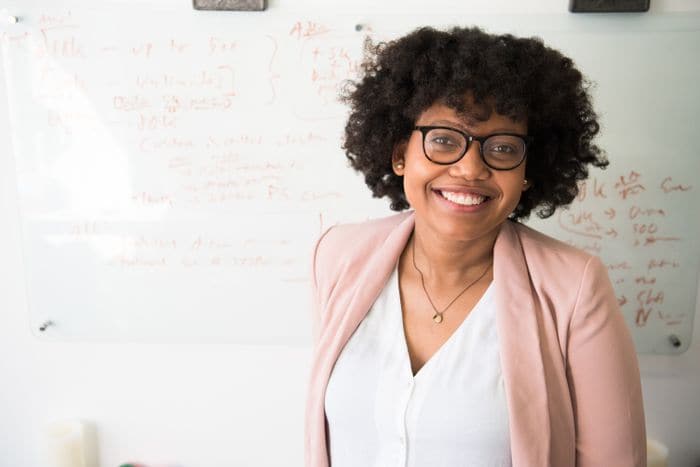 A smiling woman in glasses standing in an office